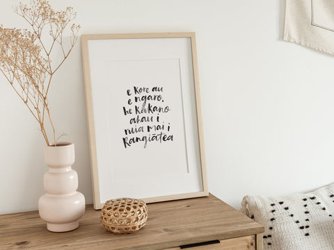 A4 Māori art print with handwritten quote “E kore au e ngaro...” framed and styled in a modern, natural home setting.