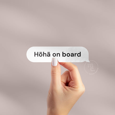 Hand holding 'Hōhā on board' Māori vinyl sticker decal on a plain background, showcasing the phrase
