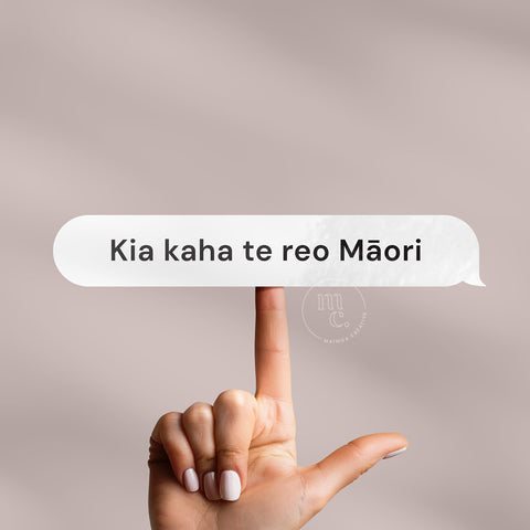 Finger balancing 'Kia kaha te reo Māori' Māori vinyl sticker decal on a plain background, showcasing the phrase
