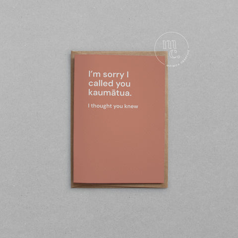 Greeting card with text 'I'm sorry I called you kaumātua. I thought you knew.' on a earthy orange background, placed on a light surface