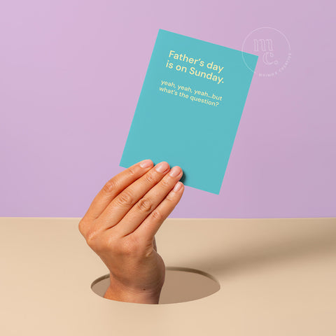 Hand popping out on a purple background holding a funny Father’s Day card with the quote “Father’s day is on Sunday. yeah, yeah, yeah…but what’s the question?” by Maimoa Creative.