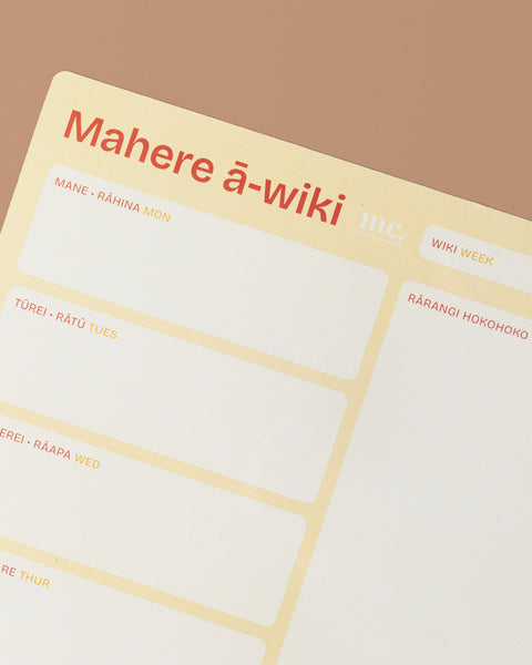 Close up of a yellow magnetic weekly planner on a beige background