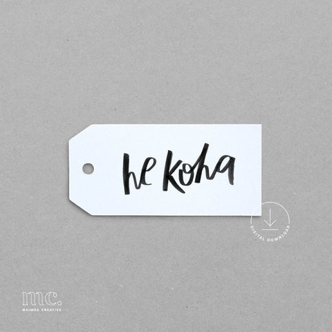 White gift tag with 'he koha' text on a gray background