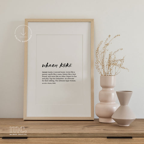Framed 'Whaea Kēkē' print displayed on a wooden sideboard, accompanied by a trio of neutral-toned ceramic vases with dried botanicals.