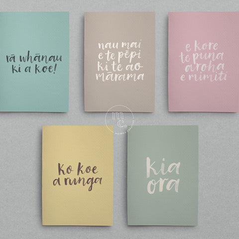 A selection of pastel coloured greeting cards with Māori greetings on them