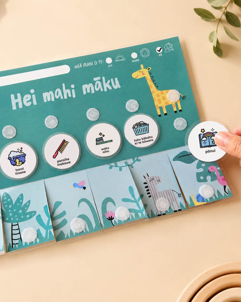te reo māori flip chart with zoo animals and routine cards stuck on with velcro dots on a light background