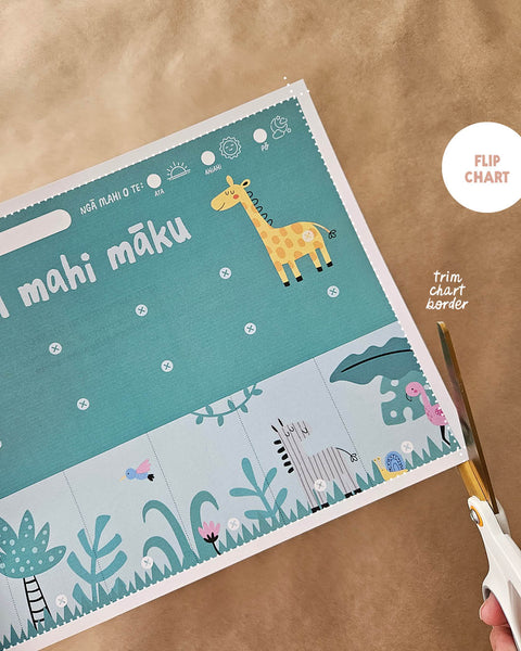 trimming the border of a reo Māori routine flip chart with zoo animal illustrations