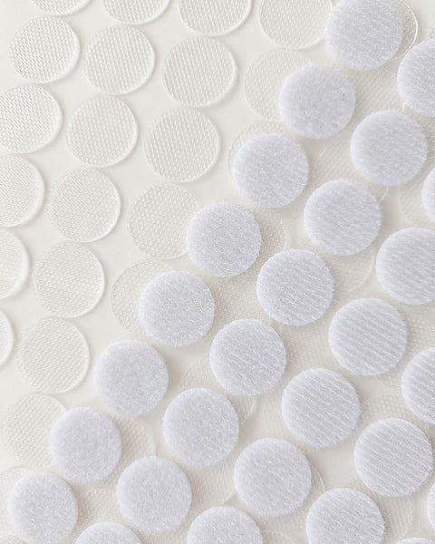 close up of small self-adhesive hook and loop velcro dots on clear sheet