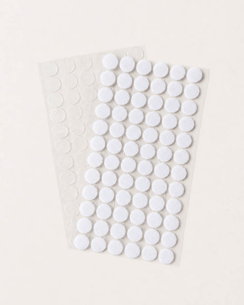 Sheet of white adhesive velcro dots on a light background