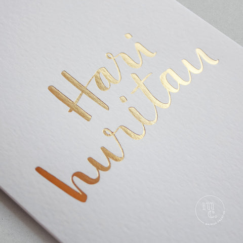 close up of a premium reo Māori greeting card with 'Hari Huritau' in gold foil lettering