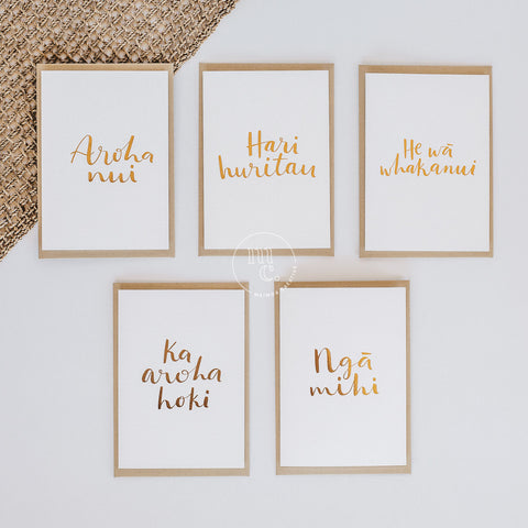 selection of 5 premium greeting cards with te reo Māori phrases, gold foil on white with gold leaf envelopes