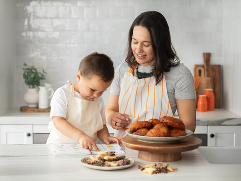 Baking scene with cookies, Edmonds Te Reo Māori cookbook, and baking tools on a kitchen counter