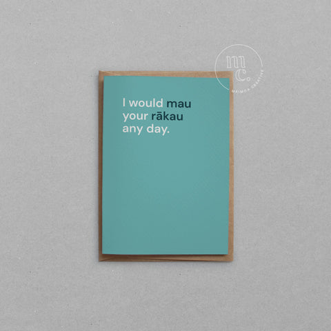 Greeting card with text 'I would mau your rākau any day.' on a bright teal background, placed on a light surface