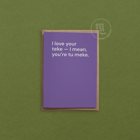 Greeting card with text 'I love your teke — I mean, you’re tu meke.' on a bright purple background, placed on a contrasting surface