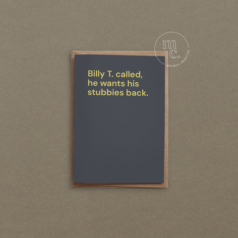 Greeting card with text 'Billy T. called, he wants his stubbies back' on a dark grey background, placed on a contrasting surface