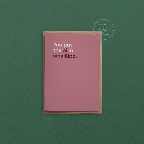 Greeting card with text 'You put the ai in whaiāipo' on a red background, placed on a contrasting surface