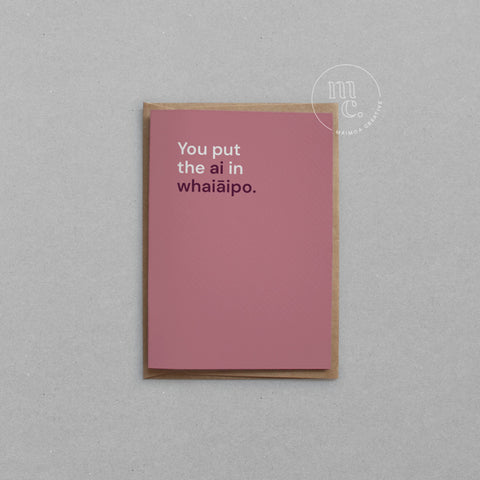 Greeting card with text 'You put the ai in whaiāipo' on a red background, placed on a light surface