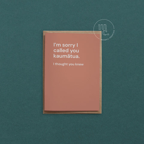 Greeting card with text 'I'm sorry I called you kaumātua. I thought you knew.' on a earthy orange background, placed on a contrasting surface