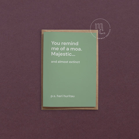 Greeting card with text 'You remind me of a moa. Majestic...and almost extinct' on a earthy green background, placed on a contrasting surface