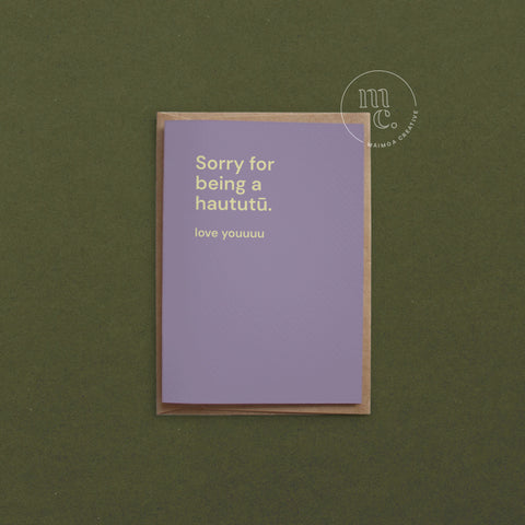 Greeting card with text 'Sorry for being a haututū. love youuuu' on a pastel purple background, placed on a contrasting surface