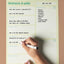 Hand writing on a large green A3 weekly magnetic planner with a brown background