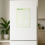 Green weekly māori magnetic planner on a white refrigerator in a kitchen setting