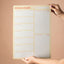 Person holding a magnetic weekly planner with 'Mahere ā-wiki' title against a beige background