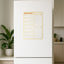 Fridge with a yellow weekly māori magnetic planner attached in a kitchen setting