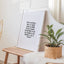 Framed print of an opening karakia print 'Tuia ki runga' by Maimoa Creative on wooden bench with sunlight and plant and mirror.