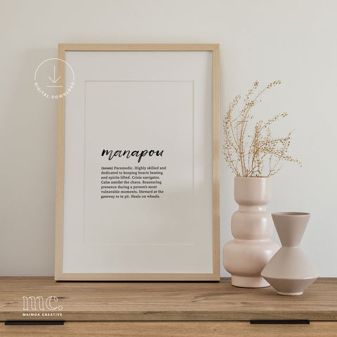 Framed 'manapou' definition print beside vases, showcasing text about a paramedic's role.