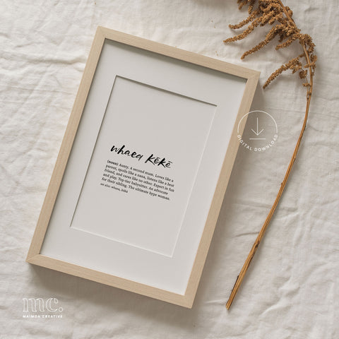 Framed 'Whaea Kēkē' print laid on a textured linen background, complemented by dried botanicals to the side.