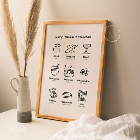 A stylish framed print displaying 'Baking Terms in Te Reo Māori' alongside a modern vase and dried grass, set in a cozy home environment.