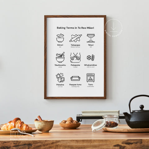 Framed 'Baking Terms in Te Reo Māori' displayed on a kitchen counter, complemented by fresh pastries, nuts, and a classic teapot, creating a warm and inviting baking scene.