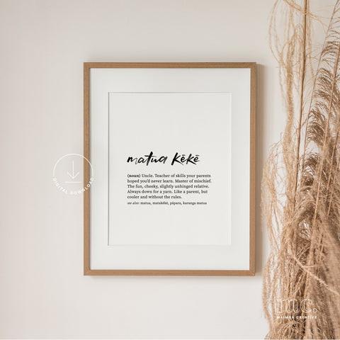 Framed 'uncle / matua kēkē' definition print with text on a white wall next to dried plants