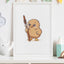 Framed artwork of a cartoon kiwi bird holding a taiaha on a shelf with decorative items.