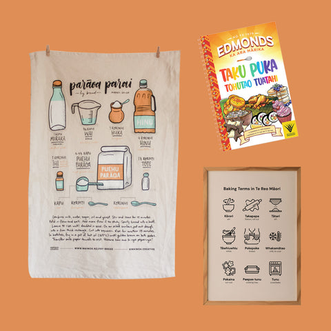 Collection of Māori kitchen and baking educational items including a tea towel with fry bread recipe, a Māori baking terms poster, and an Edmonds te reo Māori cookbook.