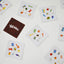 Colourful Tākaro card game cards with various symbols on a white surface